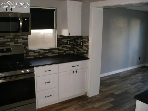 a kitchen with granite countertop a refrigerator and a sink