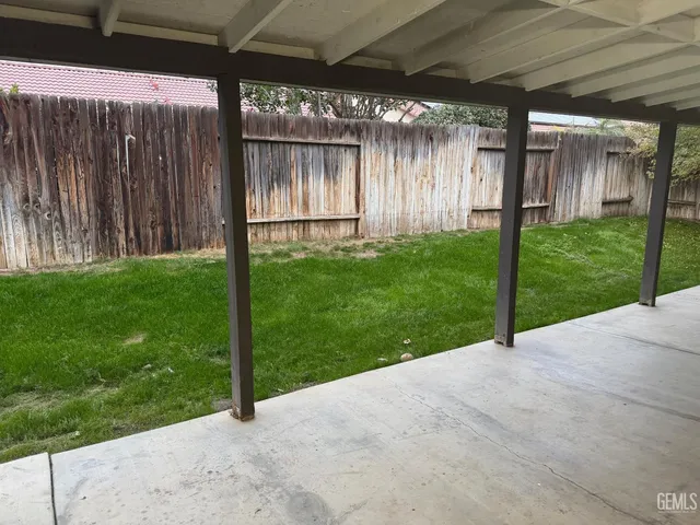 a view of a backyard with wooden fence