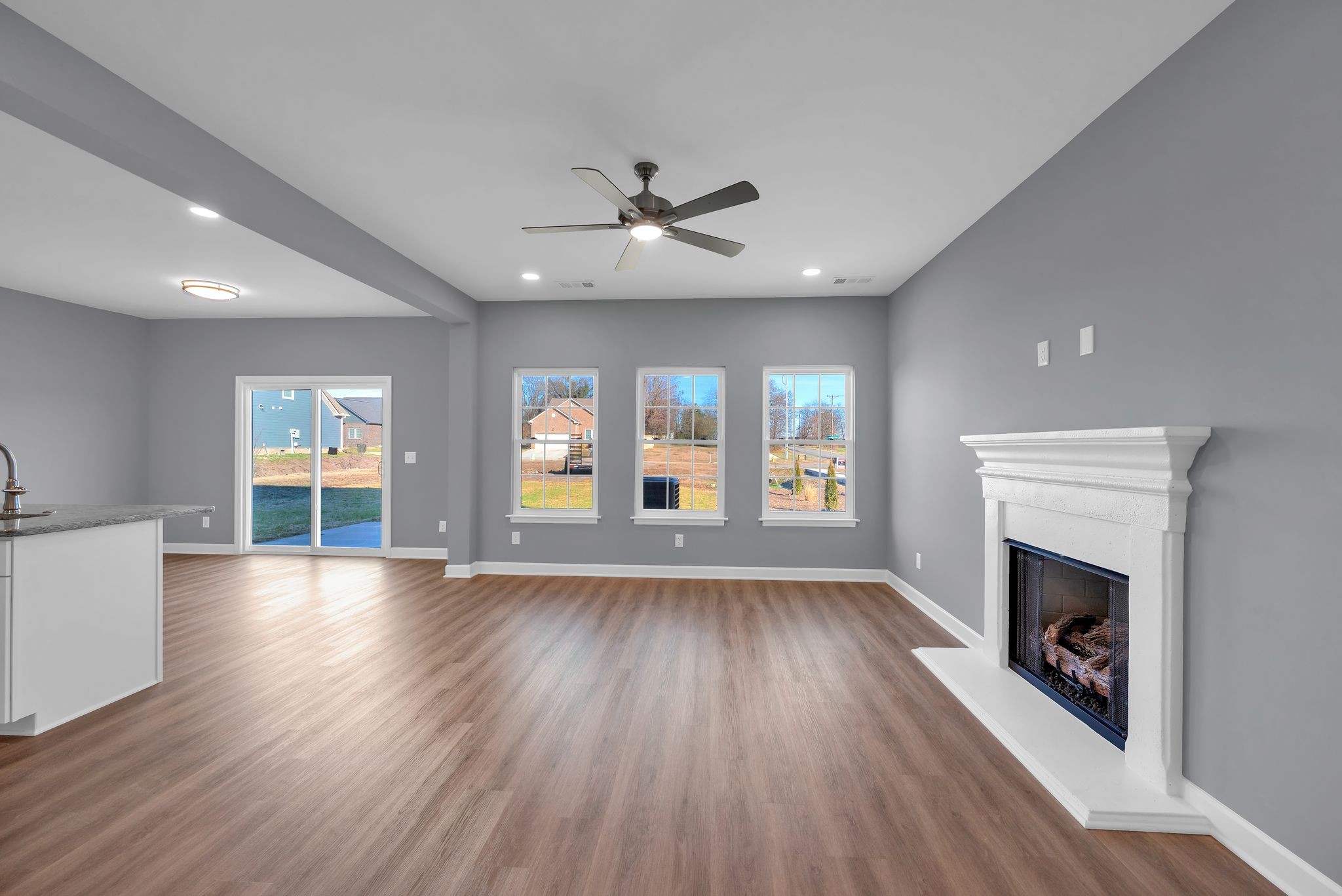 889 Blessing Way Gallatin, TN 37066 - Photo 7 of 37 an empty room with wooden floor fireplace and windows
