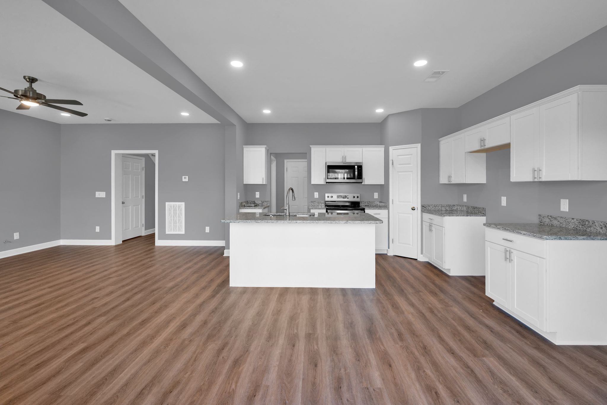 889 Blessing Way Gallatin, TN 37066 - Photo 10 of 37 a large kitchen with kitchen island a stove a sink dishwasher a microwave oven and cabinets with wooden floor
