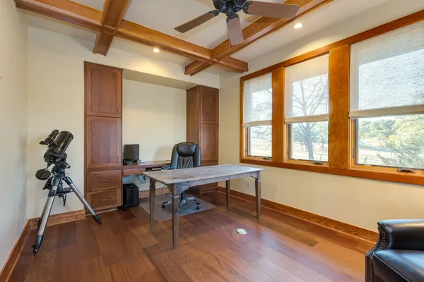 a view of a workspace with furniture window and wooden floor