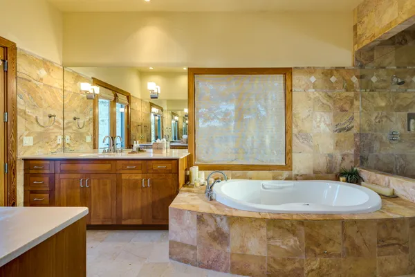 a bathroom with a tub sink and mirror