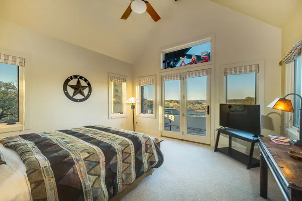 a spacious bedroom with a bed a television and a large window