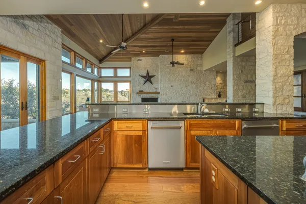 a large kitchen with granite countertop a sink and a counter top space