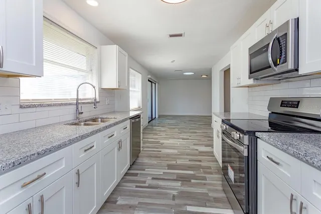 a kitchen with stainless steel appliances granite countertop a stove and a sink