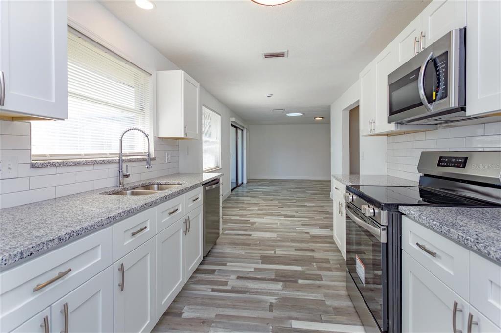 4319 South Peninsula Drive Ponce Inlet, FL 32127 - Photo 11 of 25 a kitchen with stainless steel appliances granite countertop a stove and a sink