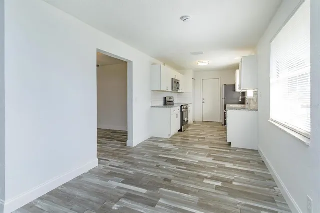 a view of a kitchen with wooden floor and a refrigerator