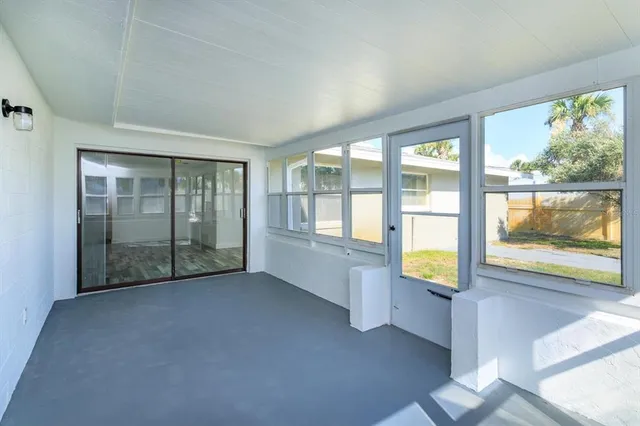 an empty room with floor to ceiling windows with wooden floor