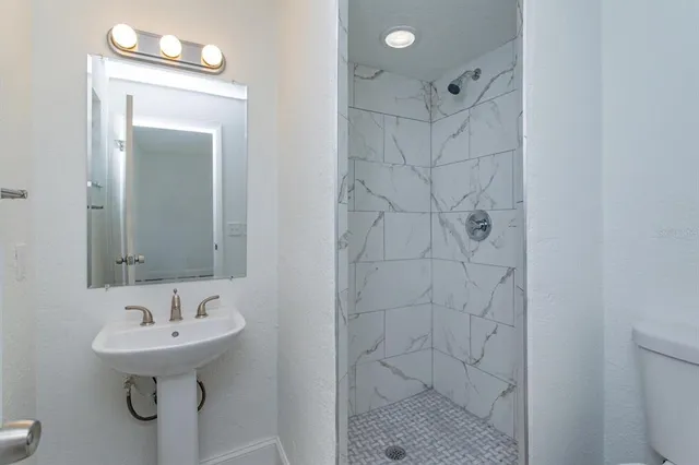 a bathroom with a sink a toilet and shower