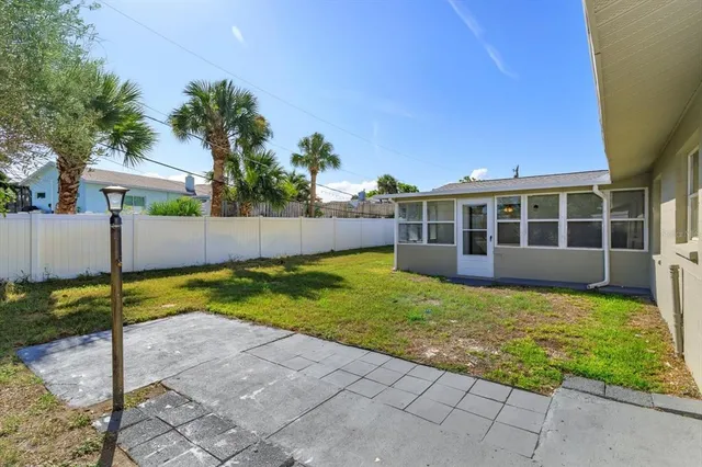 a view of house with backyard and trees