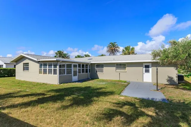 a view of a house with a yard potted plants and a table