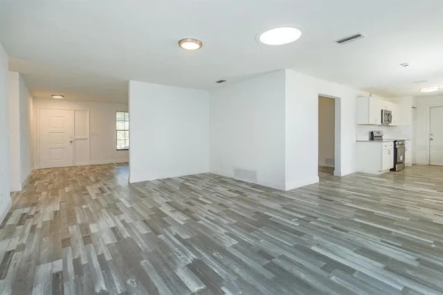 a view of empty room with wooden floor