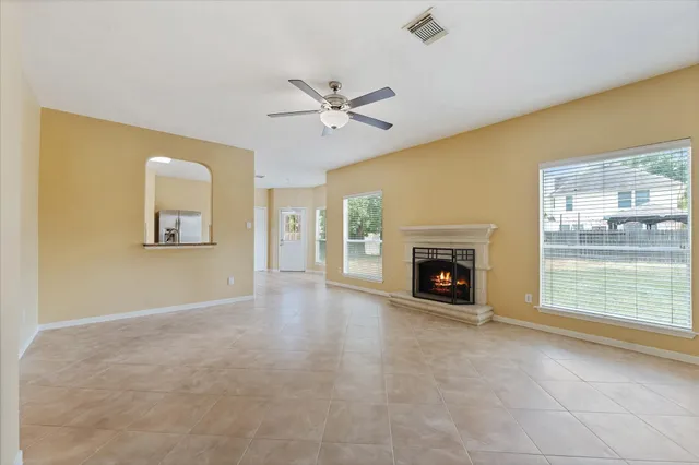 an empty room with a window and a fan