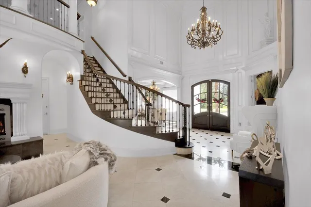 a living room with furniture a fireplace and a chandelier