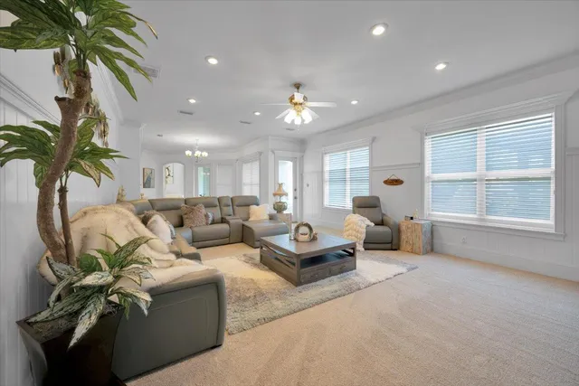 a living room with furniture a ceiling fan and a rug