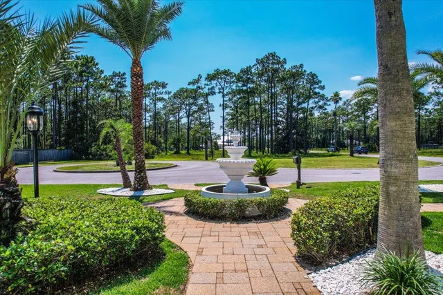 a front view of a house with a yard and potted plants