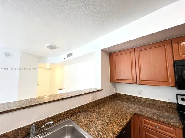 a view of a kitchen with wooden floor and cabinets
