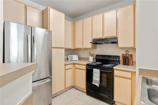 a kitchen with granite countertop white cabinets and stainless steel appliances