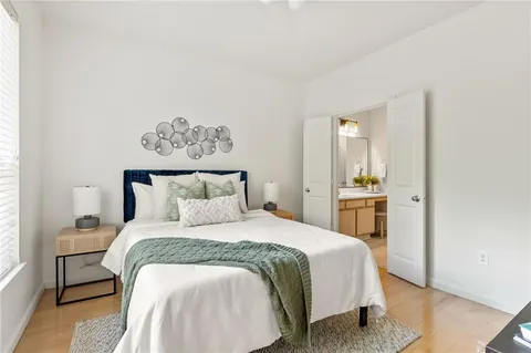 a bedroom with a bed and wooden floor