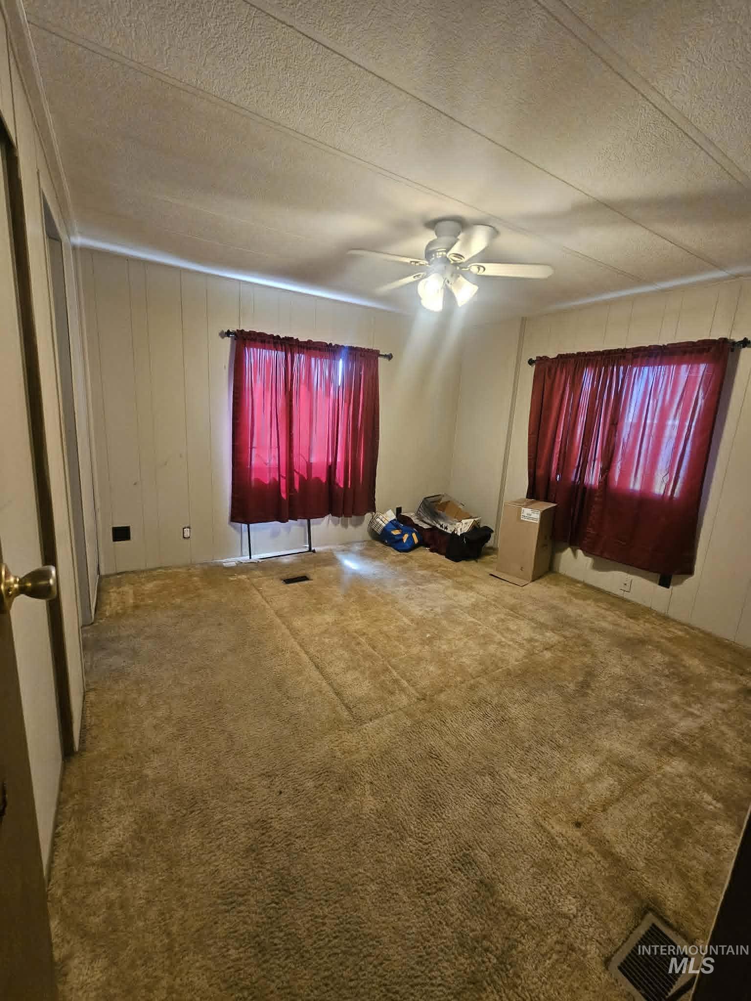 461 Greenleaf Street Boise, ID 83713 - Photo 4 of 19 Neutral wall paneling with a textured ceiling and overhead ceiling fan