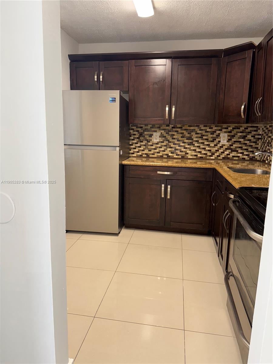 9460 Fontainebleau Boulevard, Unit 331 Miami, FL 33172 - Photo 10 of 17 a kitchen with stainless steel appliances a refrigerator sink and cabinets