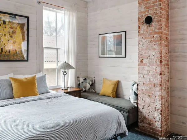 a bedroom with a bed and a painting on the wall