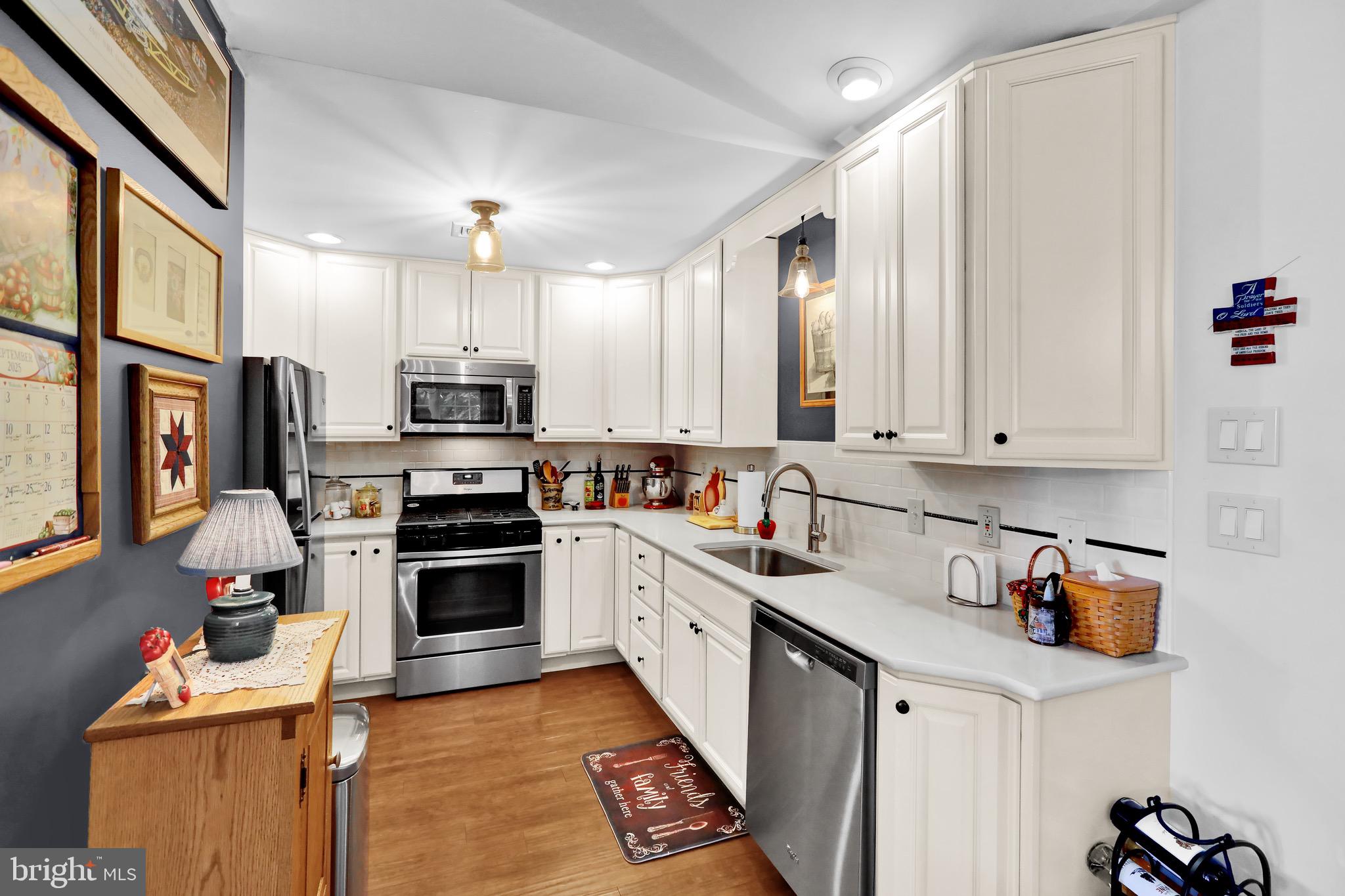 237 North 14th Street Reading, PA 19604 - Photo 10 of 26 a kitchen with stainless steel appliances granite countertop a stove top oven a sink a refrigerator and white cabinets with wooden floor
