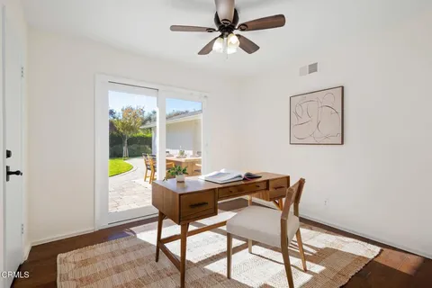 a view of a bedroom with wooden floor and window