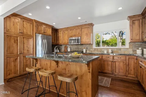 a kitchen with stainless steel appliances granite countertop a refrigerator sink and cabinets
