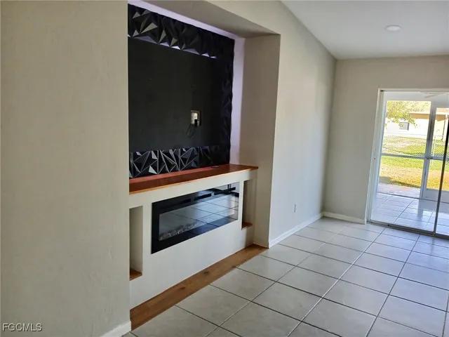 a view of an empty room with a fireplace and a window