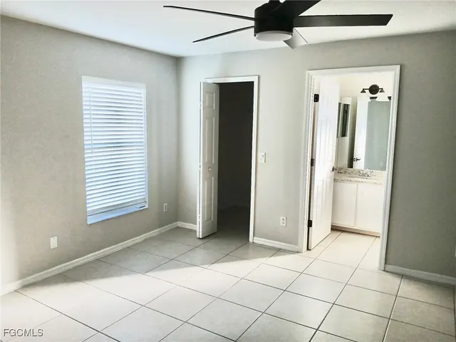 a view of an empty room with window and cabinet