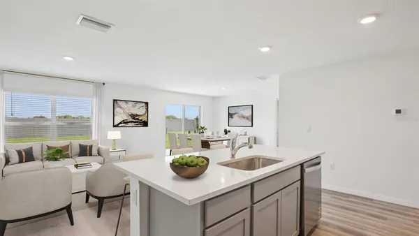 a kitchen with a sink cabinets and wooden floor