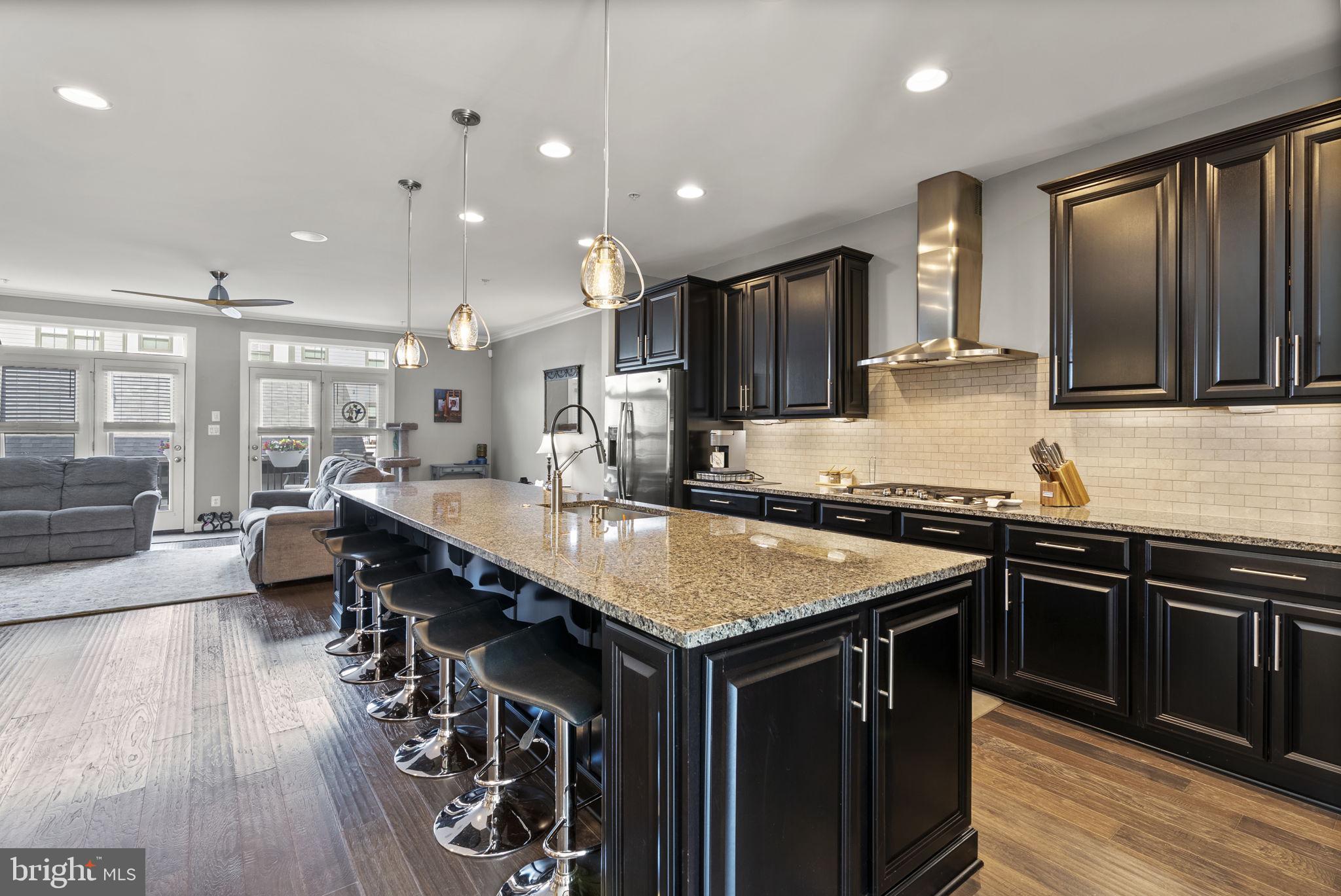 402 Redbridge Street Middle River, MD 21220 - Photo 11 of 49 a kitchen with stainless steel appliances granite countertop a stove a sink dishwasher and a microwave with wooden floor