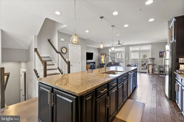 a kitchen with granite countertop a table chairs sink and a stove