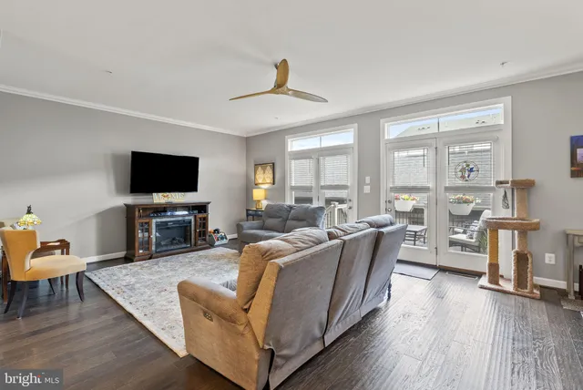 a living room with furniture a flat screen tv and wooden floor