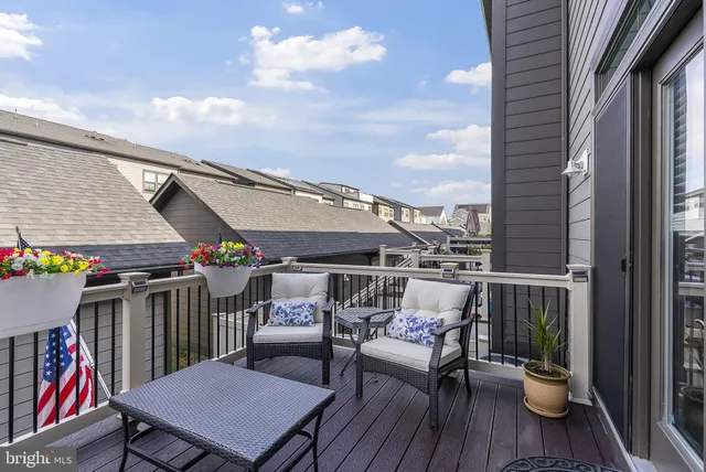 a balcony with wooden floor outdoor seating and city view