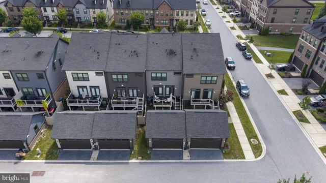an aerial view of residential houses with outdoor space and parking