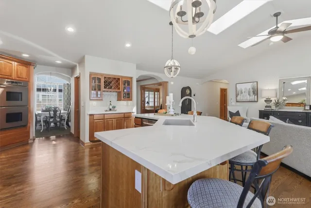 a living room with furniture kitchen view and a chandelier