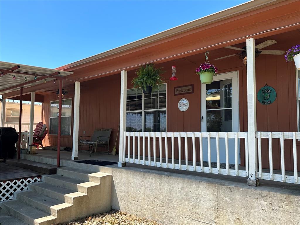 348 Lake Loop Bellevue, TX 76228 - Photo 2 of 11 a view of a deck with a chair and floor to ceiling window