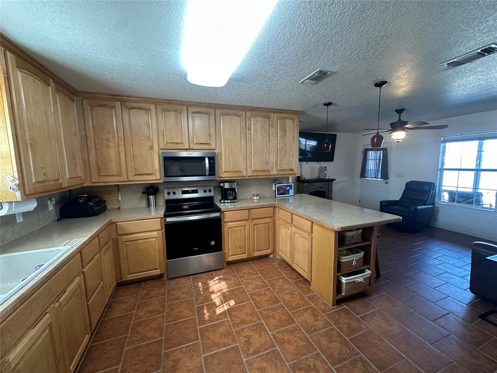 348 Lake Loop Bellevue, TX 76228 - Photo 6 of 11 a kitchen with granite countertop a stove top oven a sink dishwasher and a refrigerator