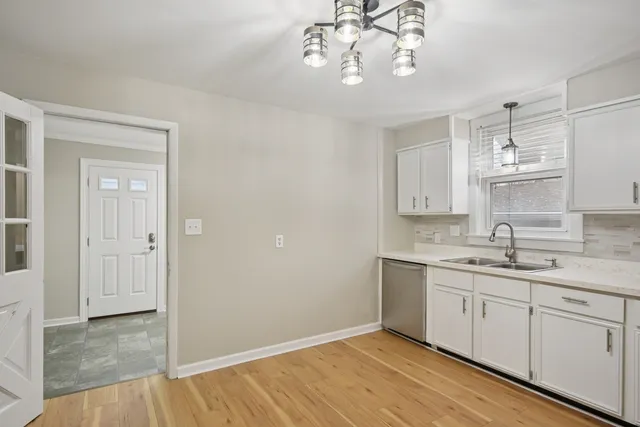 a kitchen with a sink cabinets and wooden floor