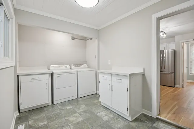 a utility room with cabinets washer and dryer