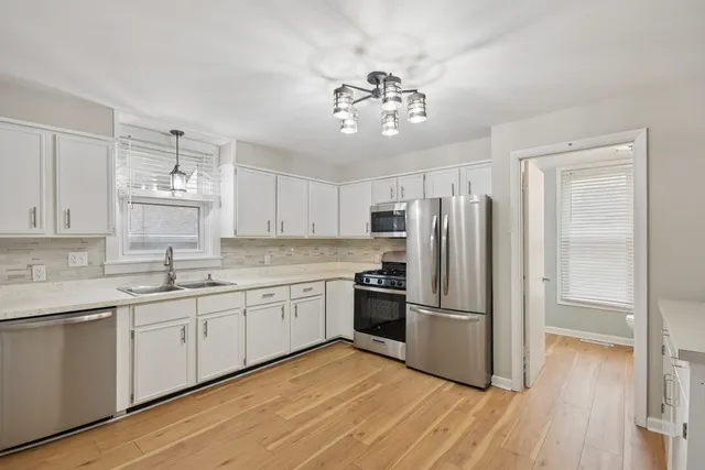 a kitchen with stainless steel appliances granite countertop a refrigerator and a sink