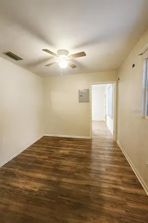 a view of empty room with wooden floor