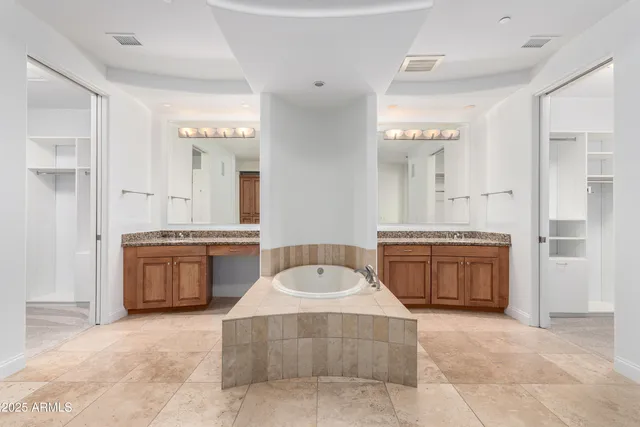 a spacious bathroom with a tub sink and mirror