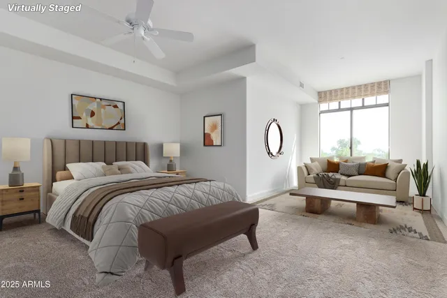 a spacious bedroom with a bed a couch and dresser next to a window