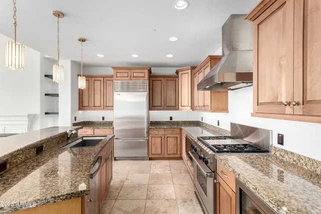 a kitchen with a stove a sink a refrigerator and blue cabinets with wooden floor