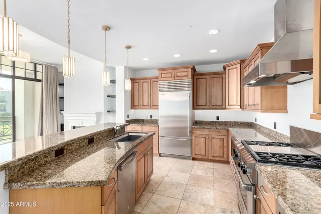 a kitchen with stainless steel appliances granite countertop a sink stove and refrigerator