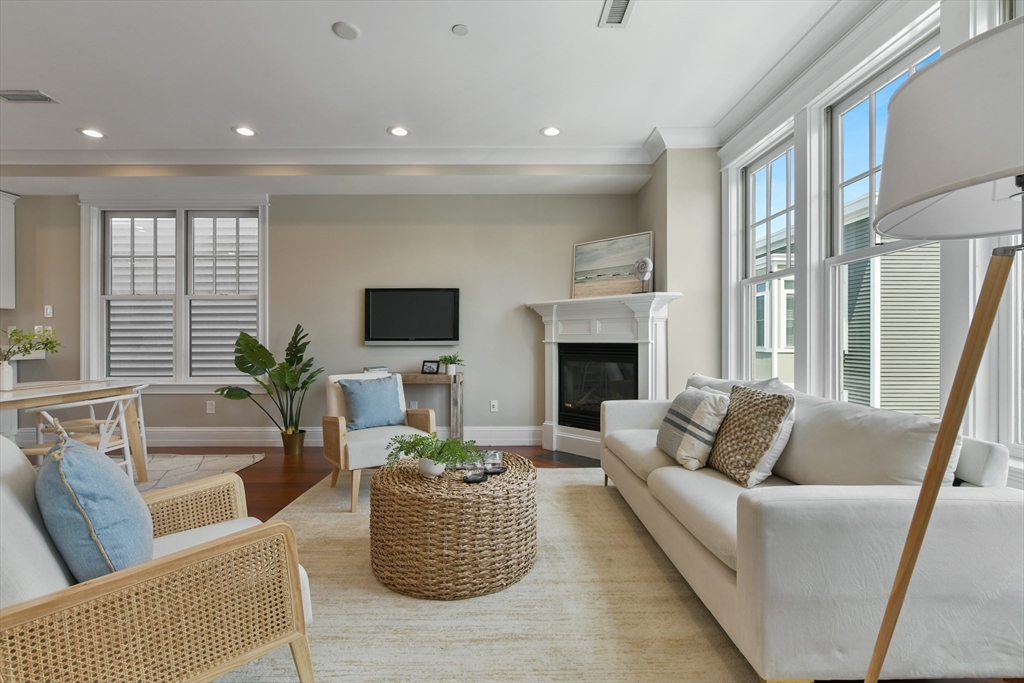 111 Bolton Street, Unit 2 Boston, MA 02127 - Photo 12 of 36 a living room with furniture a large window and a fireplace