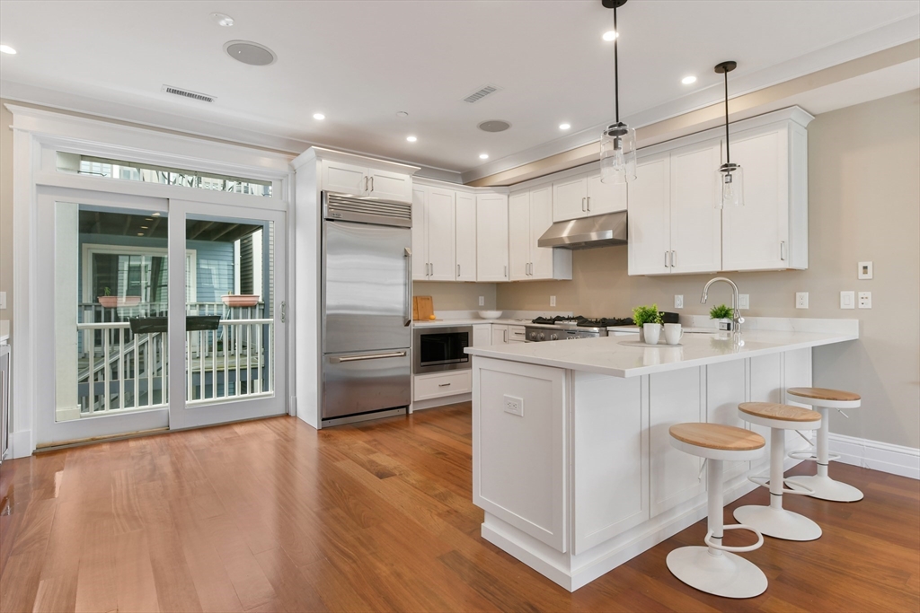 111 Bolton Street, Unit 2 Boston, MA 02127 - Photo 2 of 36 a kitchen with kitchen island stainless steel appliances a sink and cabinets